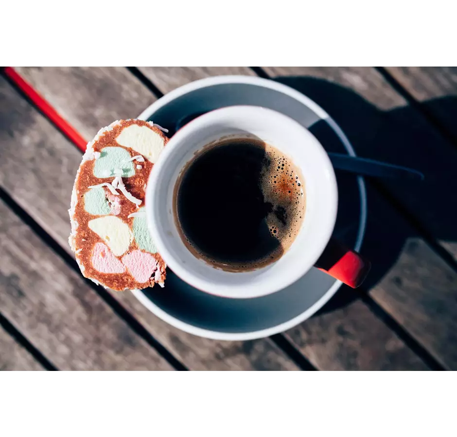 Cup of black coffee with a lollie cake on the side at The Beach House Cafe.