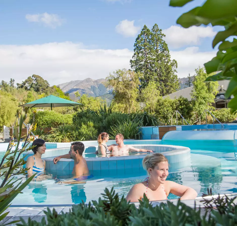Guests enjoy the hot pools, blue skies with mountains in the background 