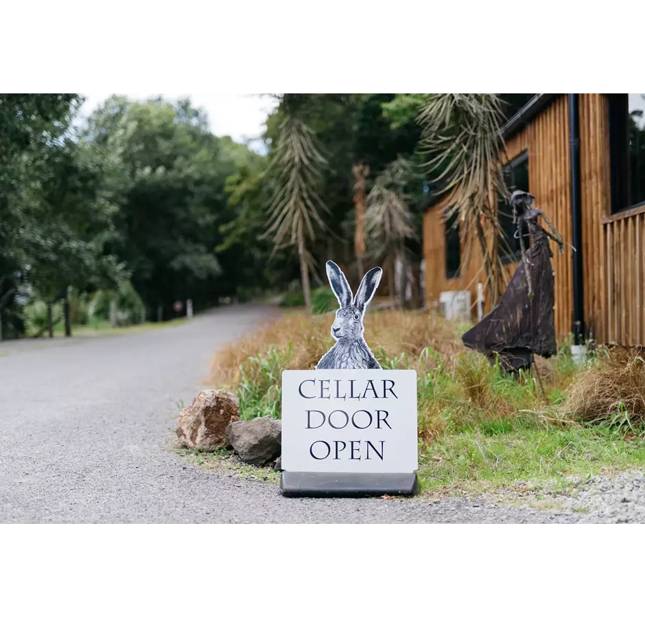 Cellar door open sign of a hare saying cellar door is open at Cross Hares Winery.