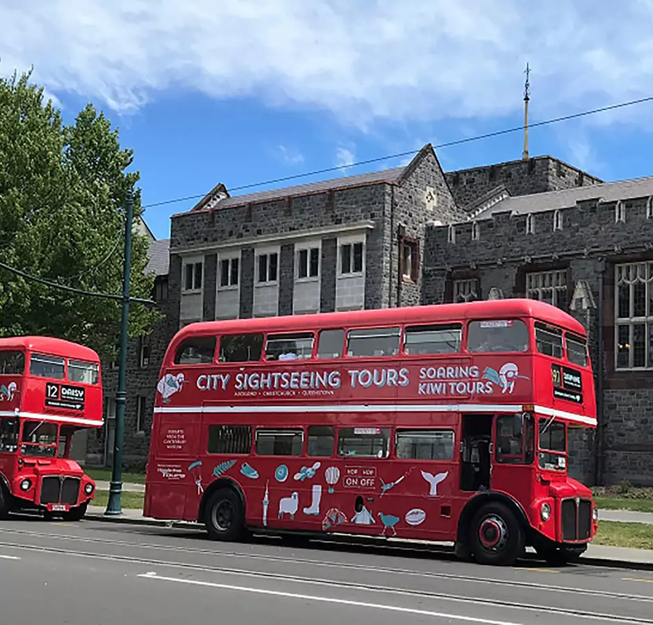 Hassle Free Tours Soaring Kiwi red double decker buses parked outside Christ College